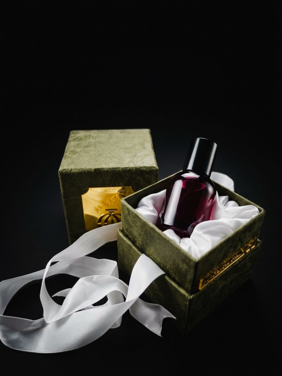 Elegant perfume bottle presented in velvet gift box with ribbon, perfect for luxury branding.